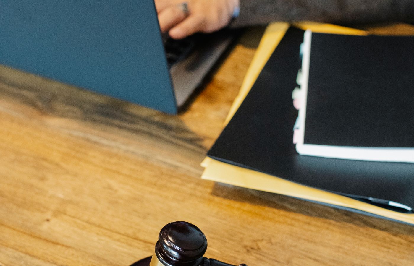 Juridisch professional aan het werk met laptop, dossiers en rechtershamer