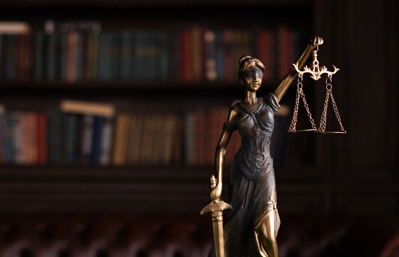 Vrouwe Justitia en rechtershamer in een klassieke juridische bibliotheek